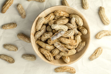 boiled peanuts in wooden cup on crumpled paper