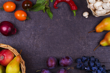 Grape, apples, pears, mushrooms, chili peppers, tomatoes, basil, red onions and glass of red wine on a wooden dark background. View from above, top studio shot of vegetables and fruits
