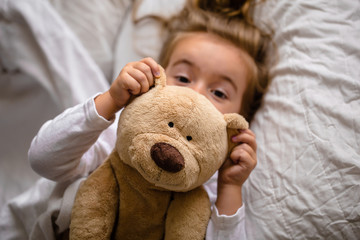 little girl in bed with soft toy the emotions of a child