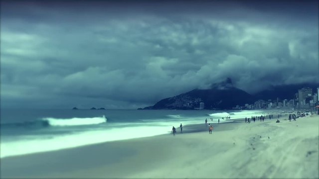 Time lapse of dark storm clouds swirling over the Ipanema Beach skyline with tilt shift narrow focus along the shore in Rio de Janeiro, Brazil