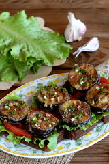 Dark bread toasts with fried eggplant, fresh tomatoes, lettuce, garlic, dill. Green lettuce on the blackboard, garlic. Healthy sandwiches with vegetables on plate on wooden background