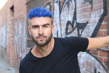 Close-up portrait of a beautiful young man with blue hair. Men's beauty, fashion.