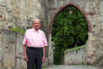 Fototapeta na wymiar Elderly man at medieval city gate of a german town