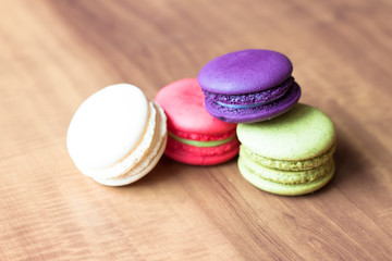 Colorful French Macarons on wooden background.