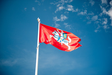 Historical state flag of Lithuania over blue sky