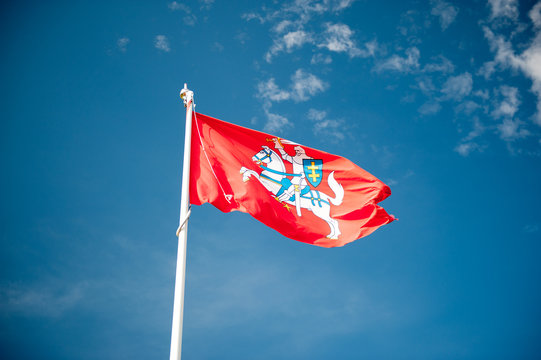 Historical state flag of Lithuania over blue sky