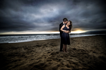 Loving engaged couple on honeymoon in a dramatic HDR beach island landscape