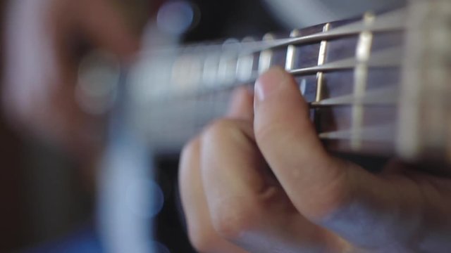 Man plays bass guitar slap close-up