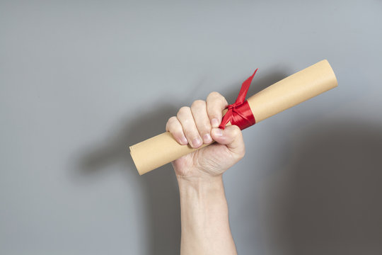 Diploma with a red ribbon in hand