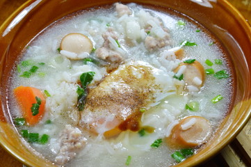 rice porridge with pork sausage topping egg on bowl