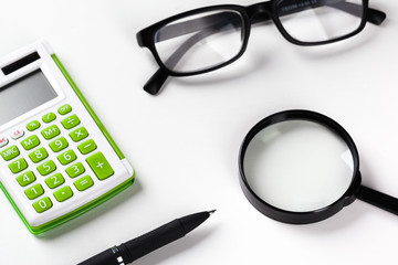 Calculator with a magnifying glass on a white background