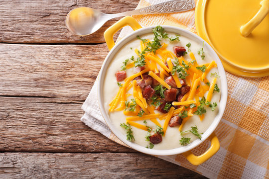 Potato puree soup with bacon and cheddar close-up in a pan. Horizontal top view
