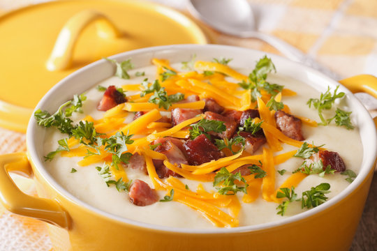 Potato puree soup with bacon and cheddar close-up in a pan. horizontal
