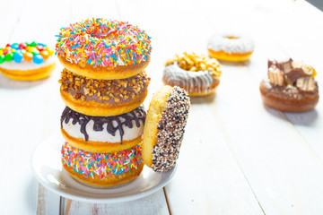 Collection of tasty donuts on white wooden board