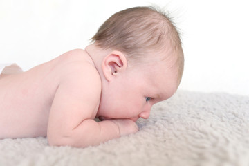 Fototapeta na wymiar Portrait of lovely blue-eyed 1 months baby lying on belly
