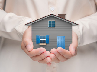 ownership concept with hand holding house model