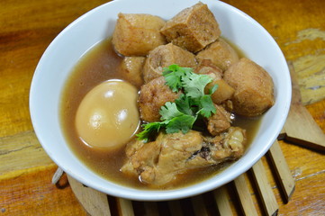 boiled egg with tofu and chicken in Chinese herb brown soup on bowl