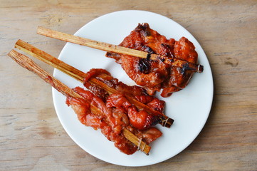 grilled chicken in wooden stick on dish