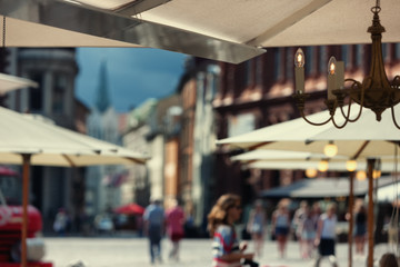 Umbrellas outdoor cafes and tourists in the square in Riga