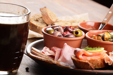 Tapas of salmon, mussels, jamon and olives with beer