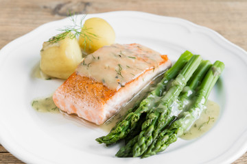 Fototapeta na wymiar Grilled salmon with boiled potatoes and asparagus on white plate