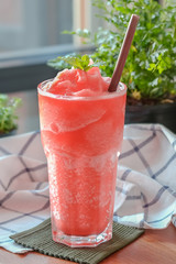 Fruit punch frappe with dark brown straw on a decorative background
