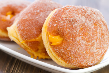 donuts on white dish on white wooden background
