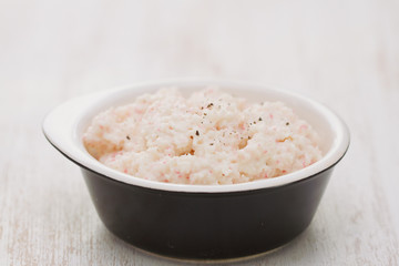 fish pate on black dish on white wooden background