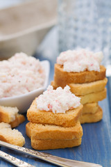 seafood pate with toasts and glass of water on blue wooden background