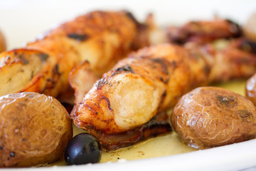 grilled squid with potato and olives on white dish