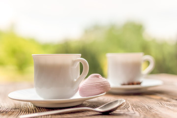 Two cups of  tea and marshmallow on rustic wooden table