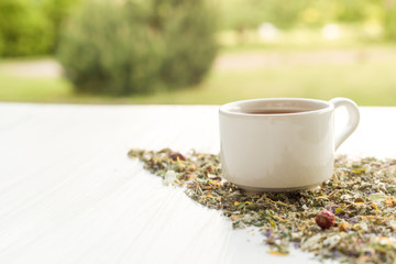 Cup of tea on table with herbs