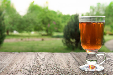 Glass of tea on table with herbs