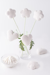 White flowers in the glass. Cookies in the shape of a heart. Cheese. Sweets. White background. High key.