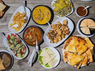 Overhead view on table with traditional georgian food: hachapuri, sacivi, bbq, salad, cheese, chadi. Selective focus