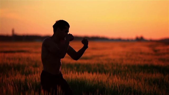 The guy is Boxing at sunset