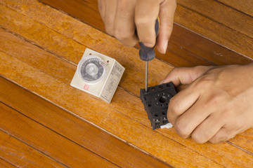 Man repairing equipment of farm on wooden background