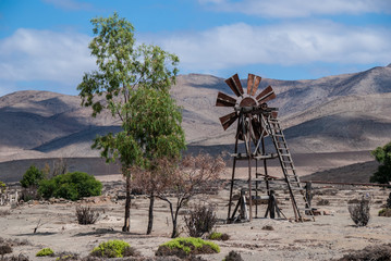 Rusty, wind-driven water pump in the Atacama desert, Chile.