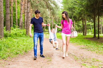 Fototapeta premium Happy young family spending time together outside in green nature.