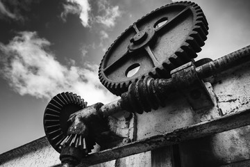 Old rusted gears under dramatic sky