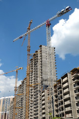Fototapeta na wymiar New high-rise modern apartment buildings construction in process ob bright sunny day side view vertical