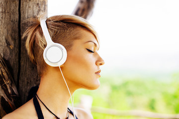 Young woman listening to music via headphones