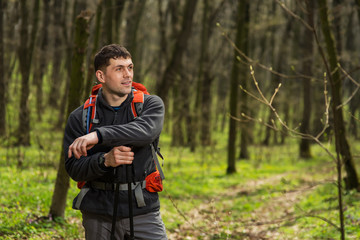 Naklejka na ściany i meble Hiker wearing hiking backpack and jacket on hike in forest.