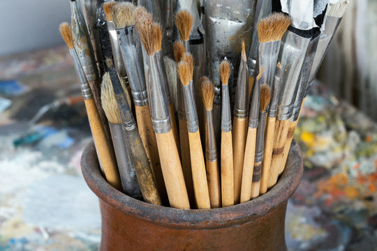 An artist's brushes covered with dust in studio. Selective focus