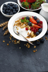 Baked muesli with fresh berries, yogurt and dark background