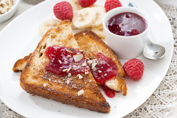 sweet breakfast - toasts with raspberries, banana and jam