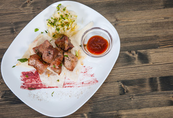 Shashlik. pieces of grilled meat with salad on a plate
