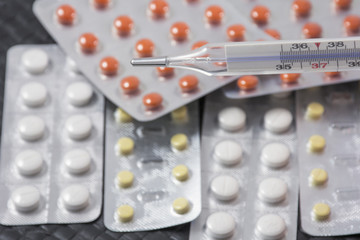 Thermometer with pills as background