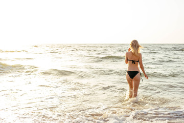 Fototapeta premium young beautiful female on beach enjoying vacation during sunset or sunrise 