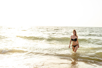 young beautiful female on beach enjoying vacation during sunset or sunrise 